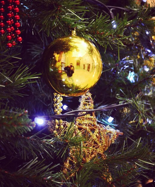 Reflection of man photographing on christmas ornament