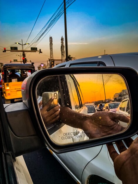 Reflection of man in side-view mirror of car