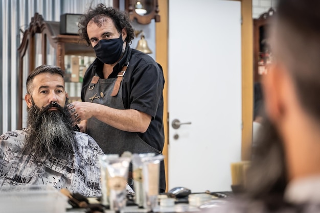 Reflection in the mirror of a barber working with a client