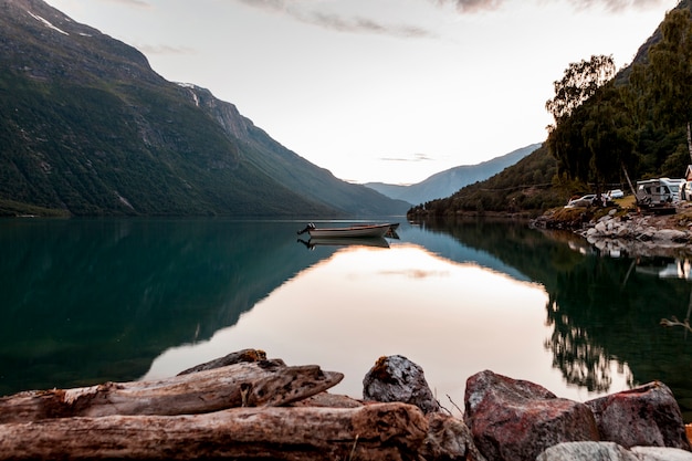 Foto riflessione di montagna e barca sul lago calmo