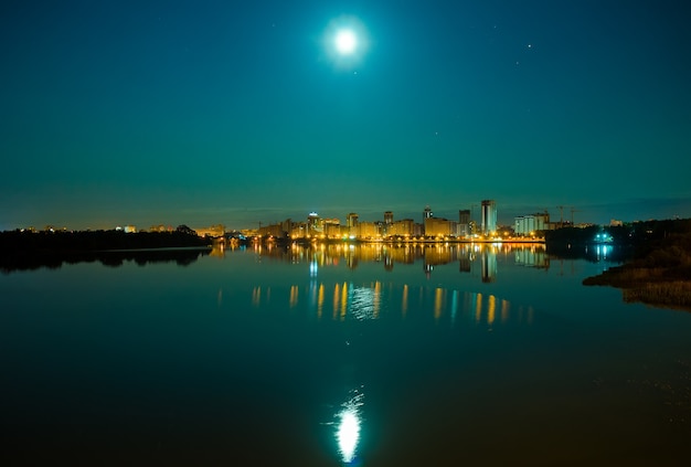Отражение ночного города на водной глади.