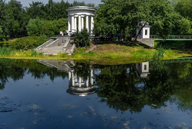 Фото Отражение беседки и деревьев на пруду в парке