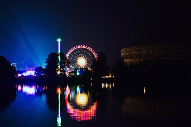 写真 夜に湖に照らされたフェリスホイールの反射