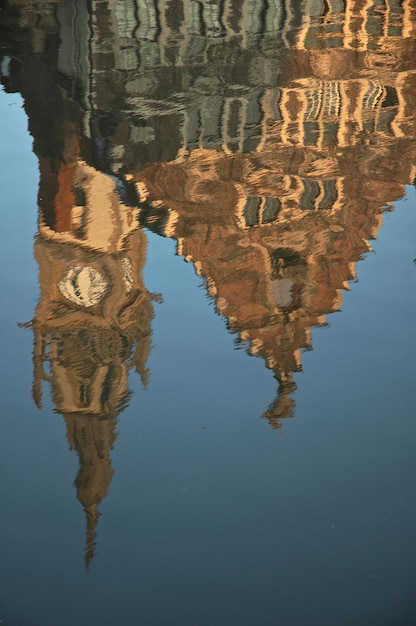 Photo reflection of old building in pond