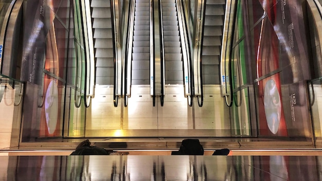 Foto il riflesso di persone sulla scala mobile della stazione della metropolitana