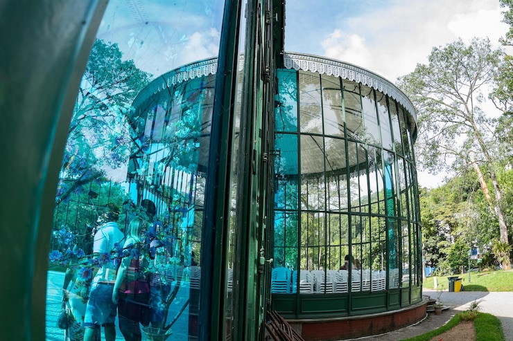 Photo reflection of people and gazebo on glass window at park