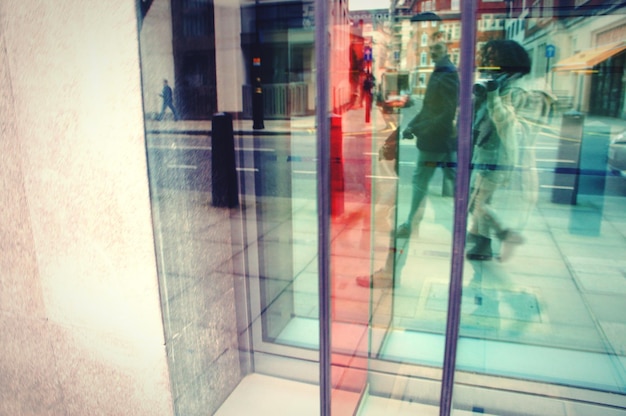 Foto riflessione delle persone sulla finestra di vetro dell'edificio