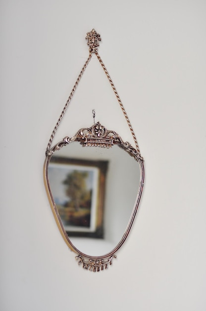 Photo reflection of picture frame on mirror hanging at wall