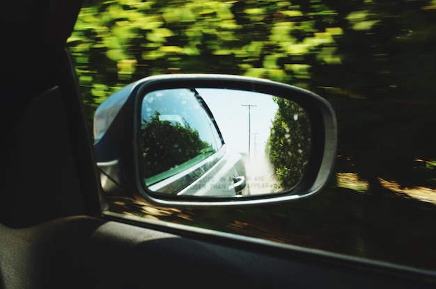 Photo reflection of road in side-view mirror