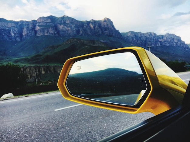 Photo reflection of road in side-view mirror