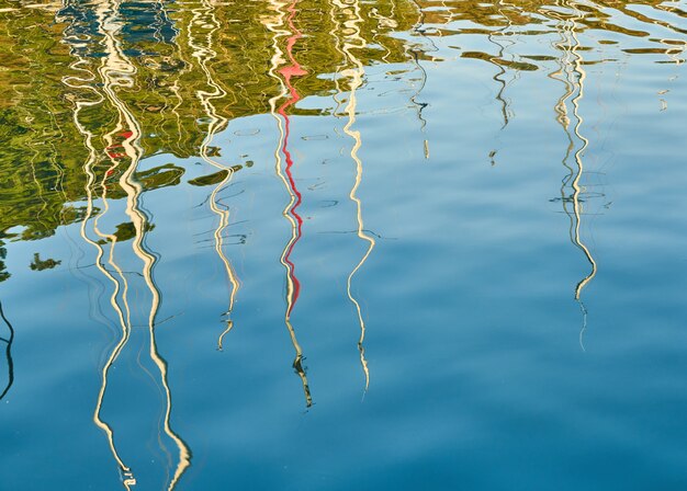 Reflection of sailboat poles at marina