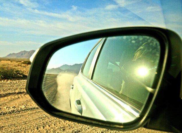 Foto riflessione nello specchio laterale di un'auto nel deserto