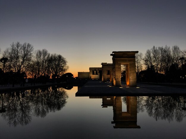 Foto riflessione delle silhouette degli alberi nel lago contro il cielo durante il tramonto