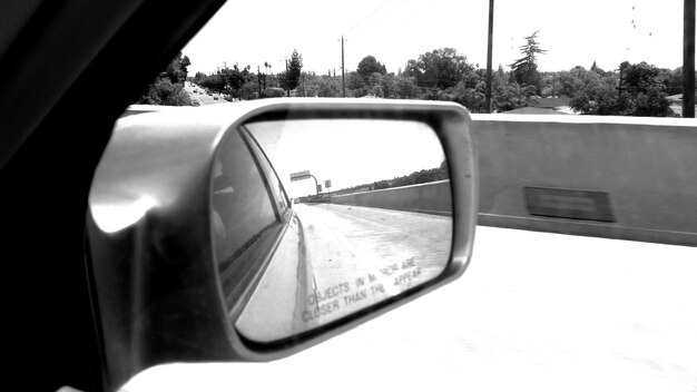 Photo reflection of snow covered street on side-view mirror