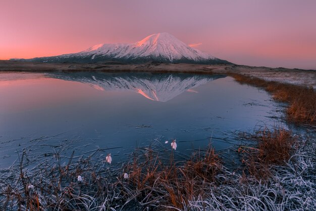 Reflection of snowcapped mountains in lake against sky during sunset