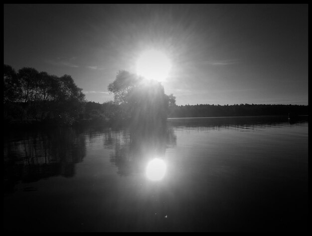 Photo reflection of sun on lake during sunny day