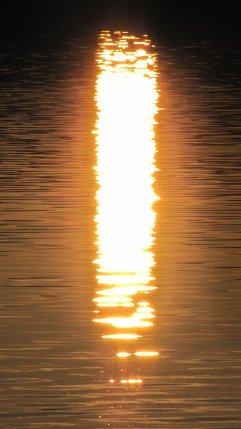 Foto riflessione della luce solare nell'acqua durante il tramonto