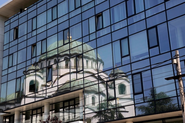 La riflessione del tempio di san sava nella capitale serba di belgrado nelle finestre dell'edificio