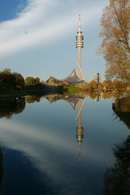 Reflection of tower in lake against sky