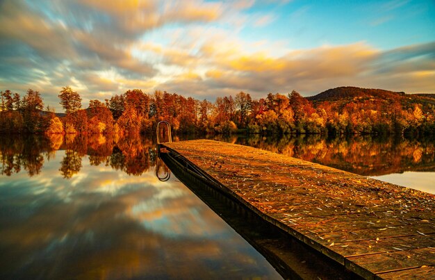 Foto il riflesso degli alberi nel lago contro il cielo durante il tramonto