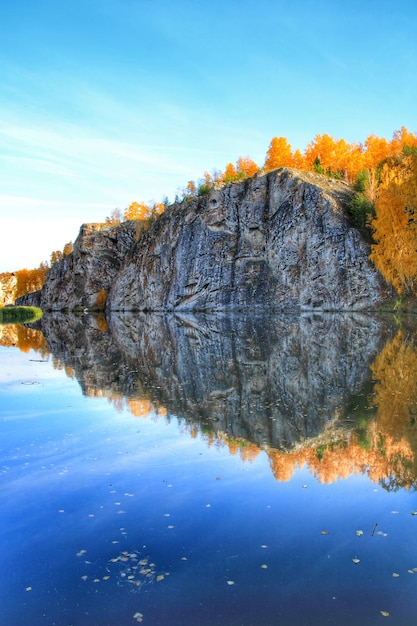 Photo reflection of trees in a river against blue sky