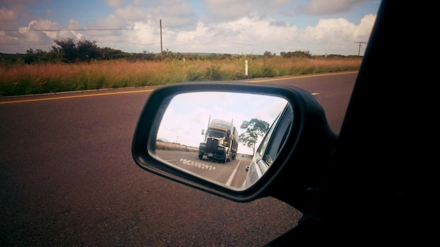 Foto riflessione del camion sullo specchio retrovisore dell'auto