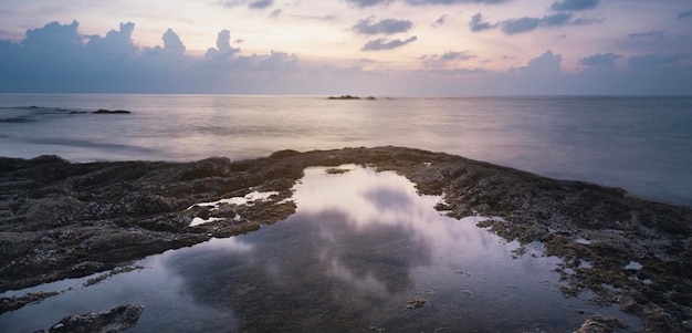 Reflection of water sunset on the seashore and rocks kaolak phuket thailand Nang tong beach