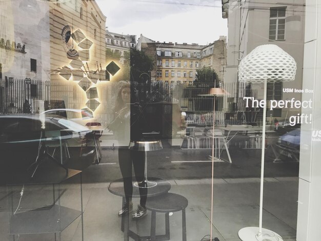 Photo reflection of woman and buildings on store window