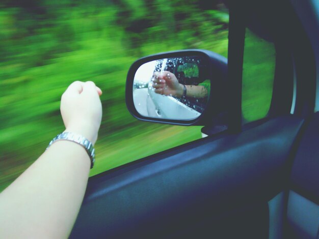 Photo reflection of woman hand in side-view mirror