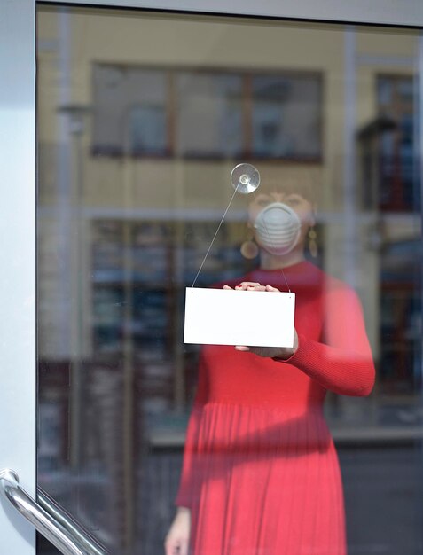 Foto riflesso di una donna con un ombrello sulla finestra di vetro