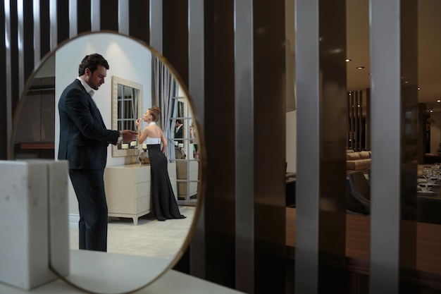 Reflection of young couple in the mirror in the room