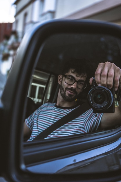 車の中で写真を撮っている若い女性の反射