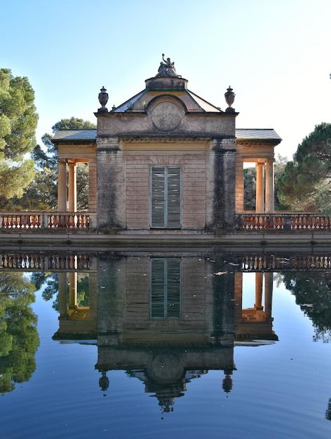 Reflejo en el estanque del pabellón neoclásico en parque de Barcelona