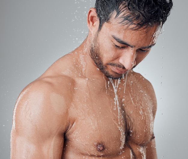 Refresh yourself with a long shower Shot of a young man taking a shower against a grey background