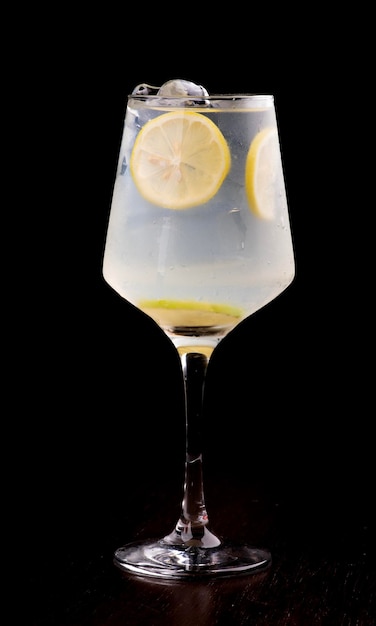 refreshing citrus cocktail glass of gin with lime dark background