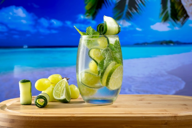 A refreshing cocktail glass with a picture of a beach in the blurred background