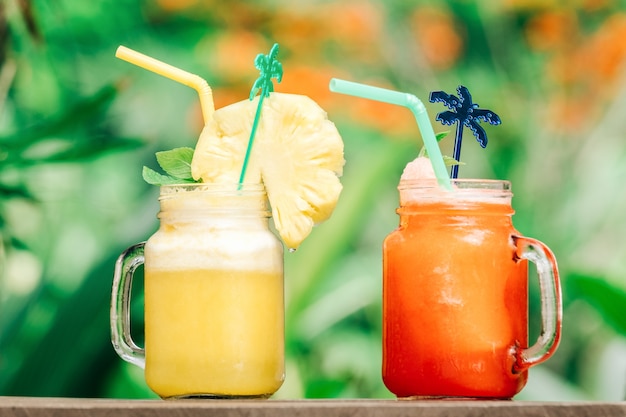 Refreshing cocktail on the table with palms