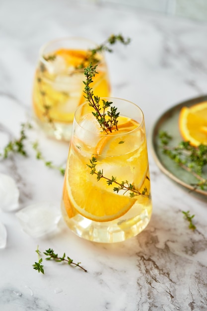 아이스 오렌지와 타임을 곁들인 상쾌한 칵테일 상쾌한 여름 수제 알코올 또는 무 알코올 칵테일 또는 목 테일 또는 디톡스 향이 첨가 된 물