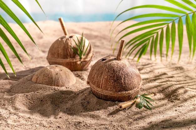 Refreshing coconut milk in shell on sandy island beach