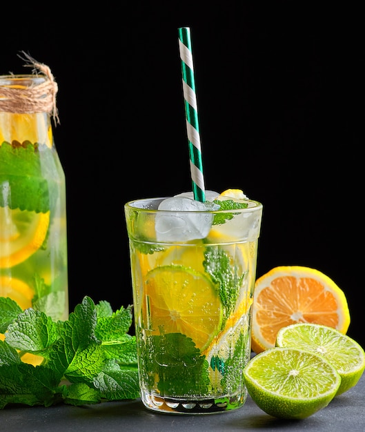 Refreshing drink lemonade with lemons, mint leaves, ice cubes and lime in a glass 