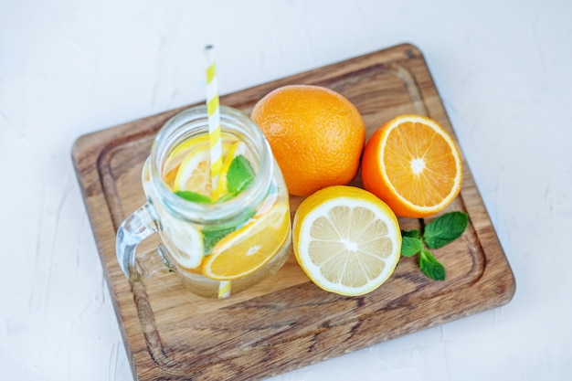 Cocktail rinfrescante alla frutta con limone, arancia e menta. estate e festa.