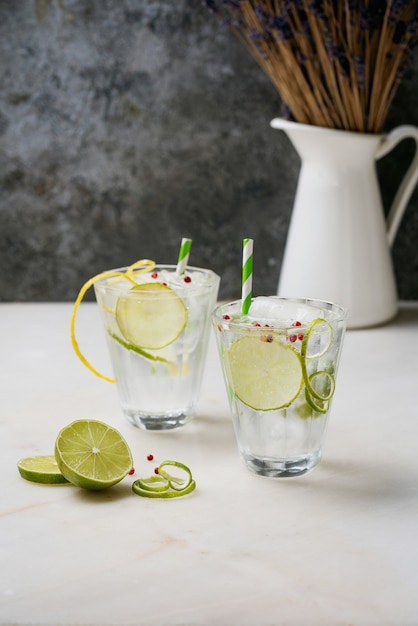 Refreshing Gin and Tonic cocktail served with lime, spices and ice over the marble desk. Selective focus