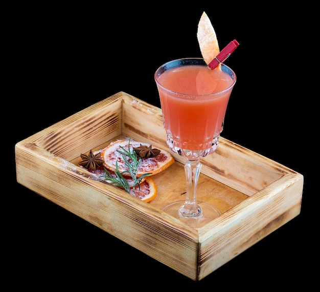 Refreshing grapefruit cocktail in a glass on a wooden Board Dark background