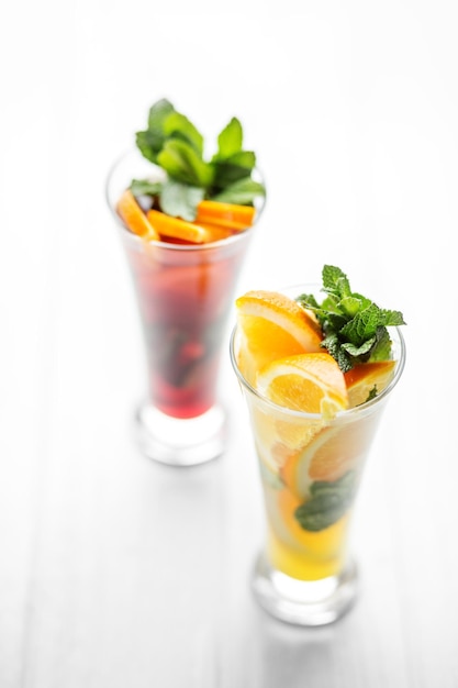 Refreshing healthy drinks with mint and citrus and pomegranate on a white background