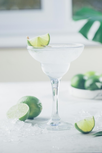 Refreshing homemade classic alcoholic margarita cocktail with lime and salt on light background