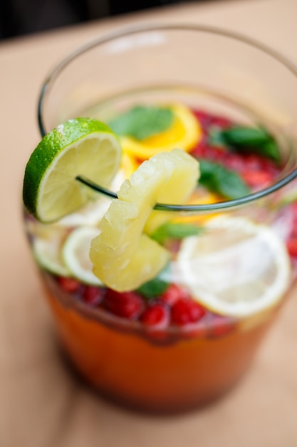 Foto limonata rinfrescante con frutta fresca arancia limone ciliegia e foglie di menta. delizioso cocktail di frutta analcolico in caraffa