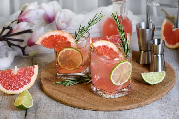 Refreshing organic cocktail with grapefruit slice lime and rosemary sprig in a glass