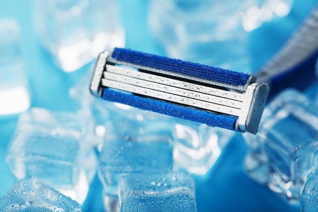 Macchina da barba rinfrescante sullo sfondo di cubetti di ghiaccio ghiacciati senza irritazioni