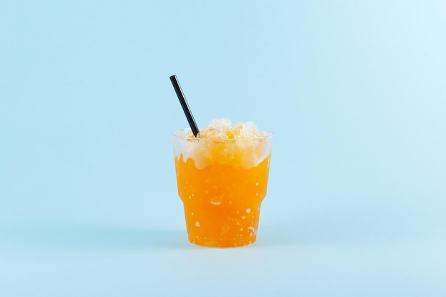 Refreshing Slush drink Orange Granizado in disposable plastic take away cup Sweet citrus Shaved ice