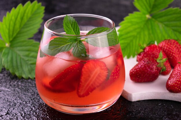 Refreshing strawberry drink with ice in a glass Closeup